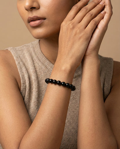 Natural Black Obsidian beaded bracelet featuring shiny 8mm black stones on white background.