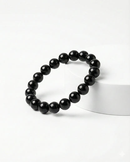 Natural Black Obsidian beaded bracelet featuring shiny 8mm black stones on white background.