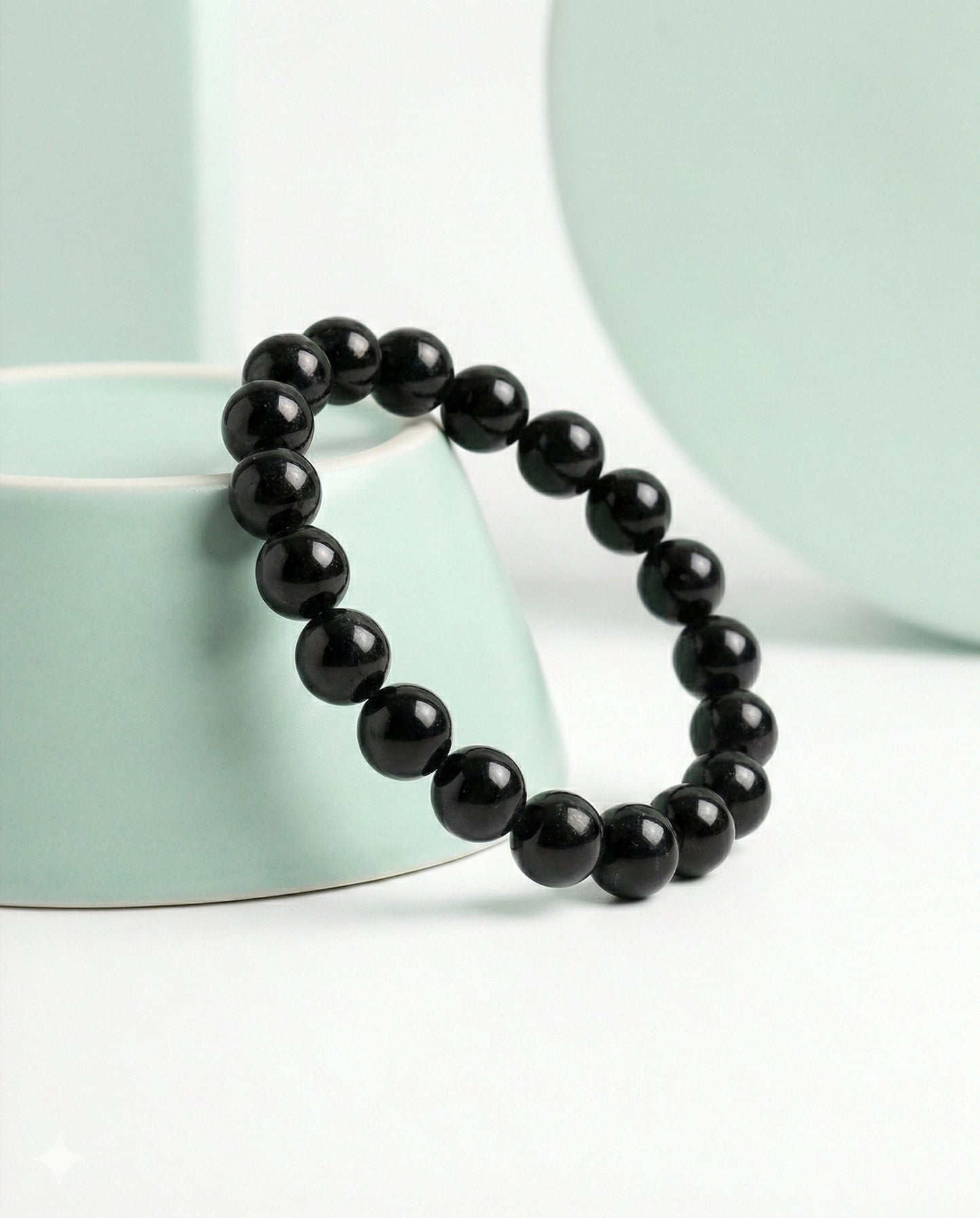 Natural Black Obsidian beaded bracelet featuring shiny 8mm black stones on white background.
