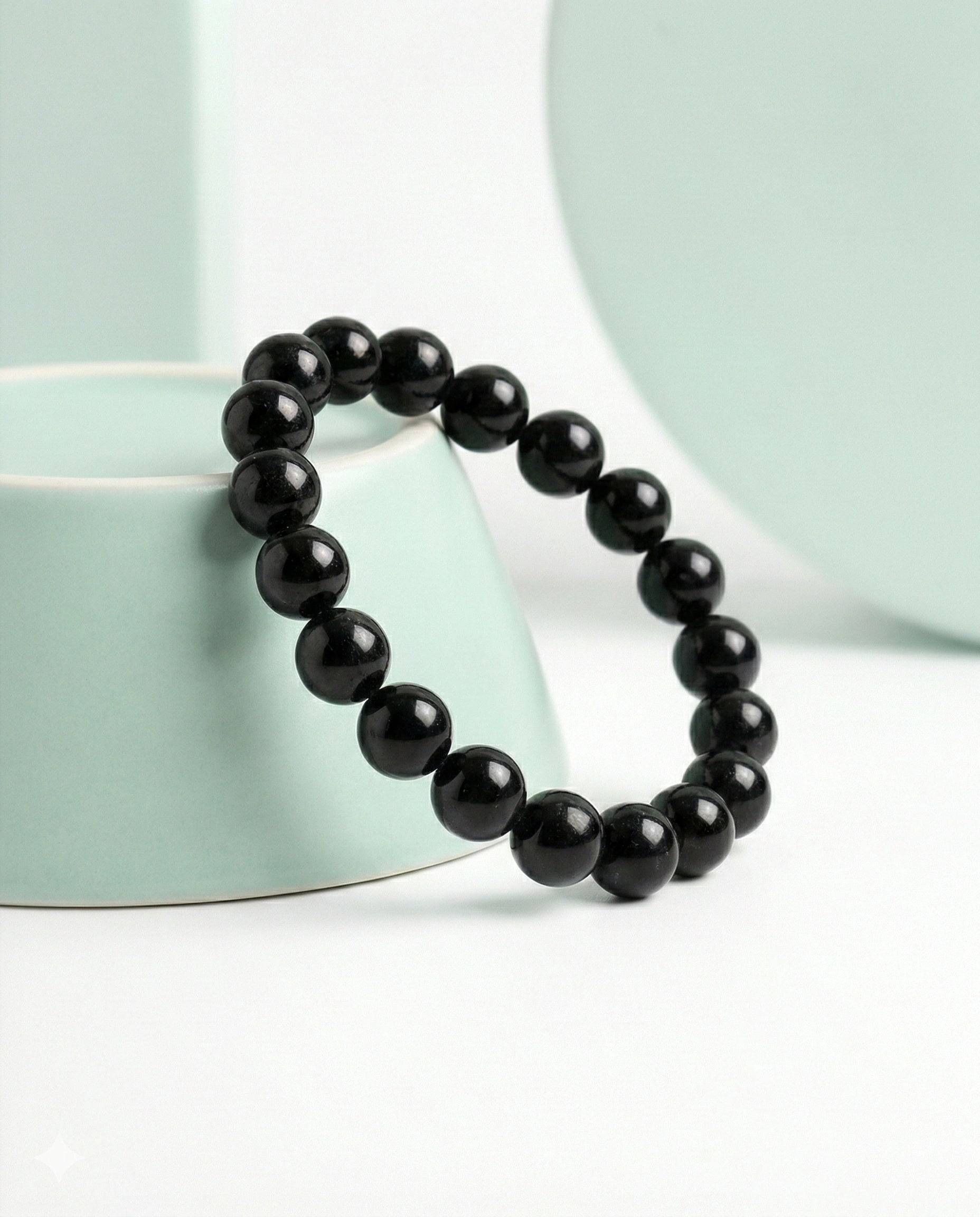 Natural Black Obsidian beaded bracelet featuring shiny 8mm black stones on white background.