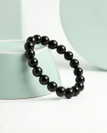 Natural Black Obsidian beaded bracelet featuring shiny 8mm black stones on white background.