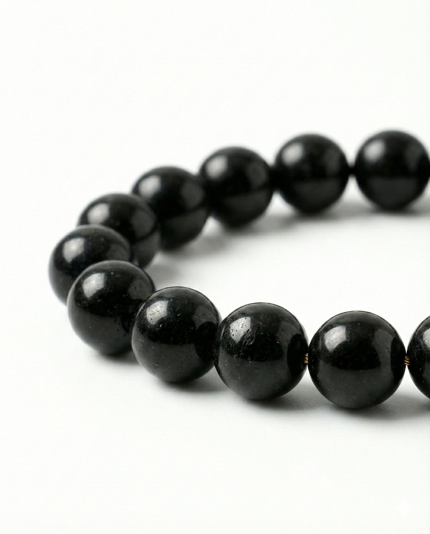 Natural Black Obsidian beaded bracelet featuring shiny 8mm black stones on white background.