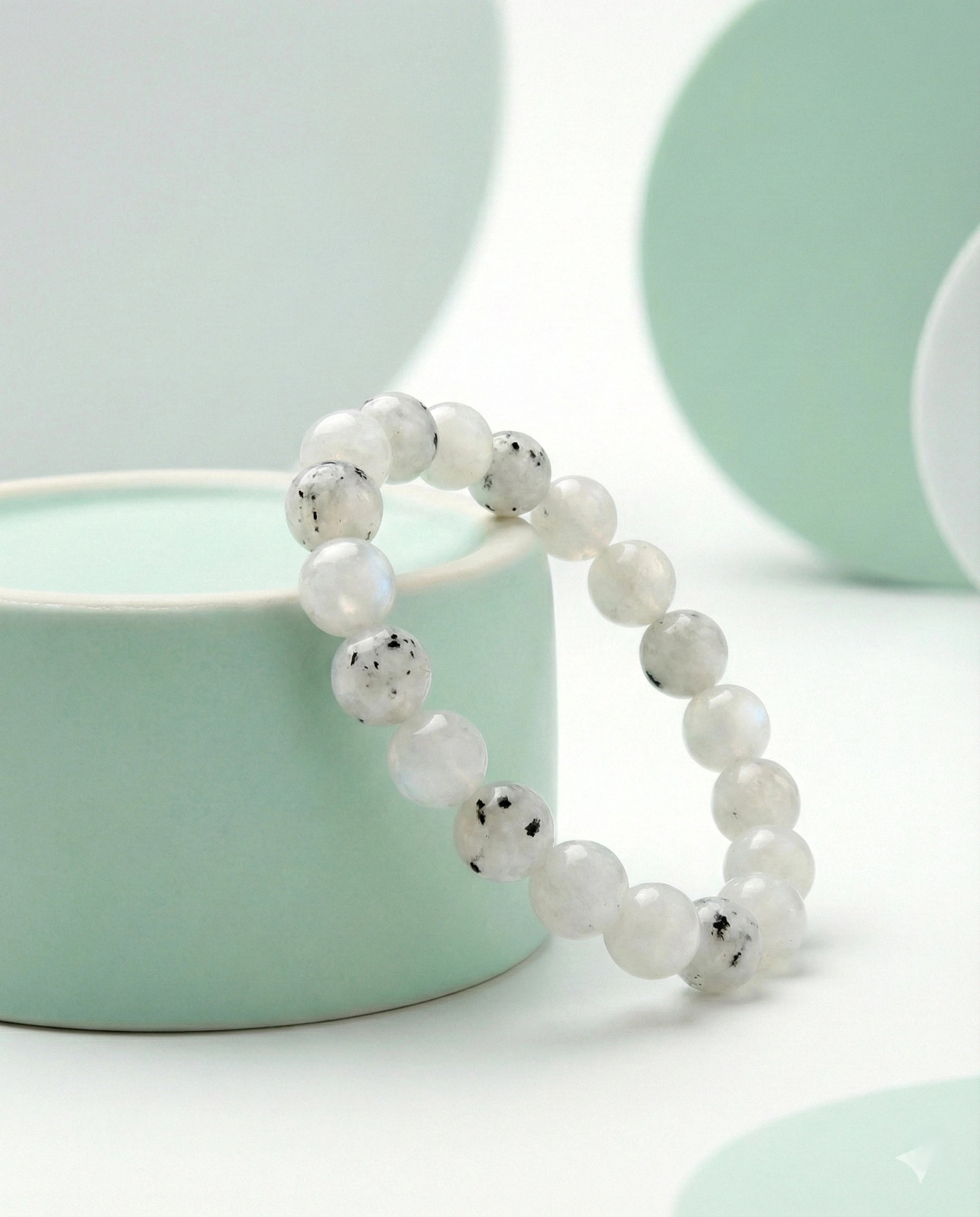 Natural Rainbow Moonstone beaded bracelet featuring 8mm white stones with black tourmaline inclusions on white background.