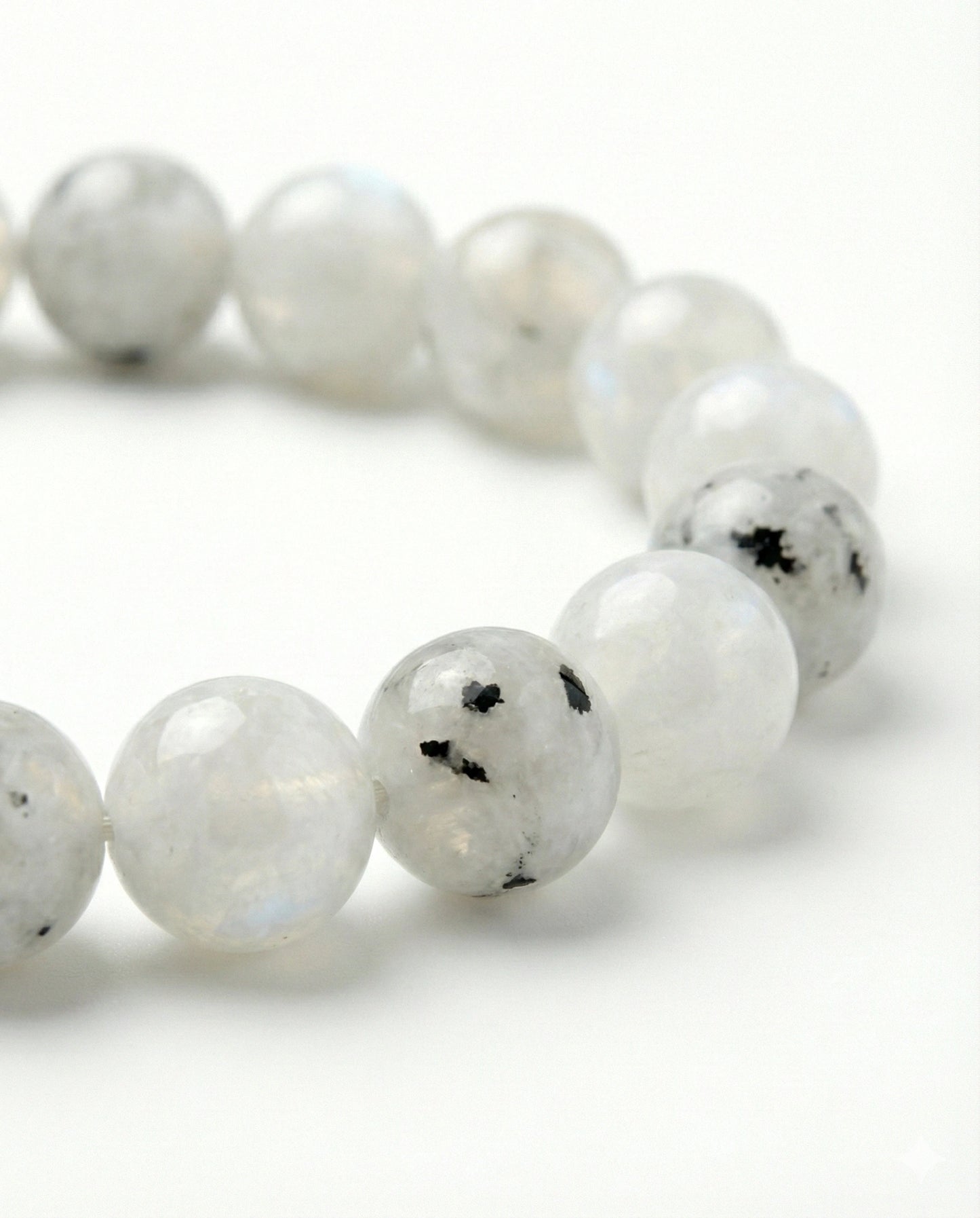 Natural Rainbow Moonstone beaded bracelet featuring 8mm white stones with black tourmaline inclusions on white background.