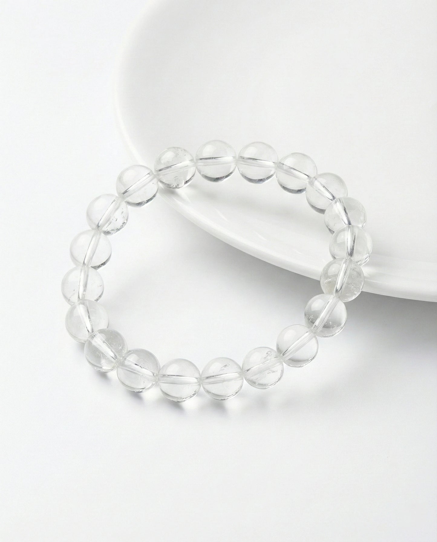 Natural Clear Quartz beaded bracelet with transparent round gemstones on black background.