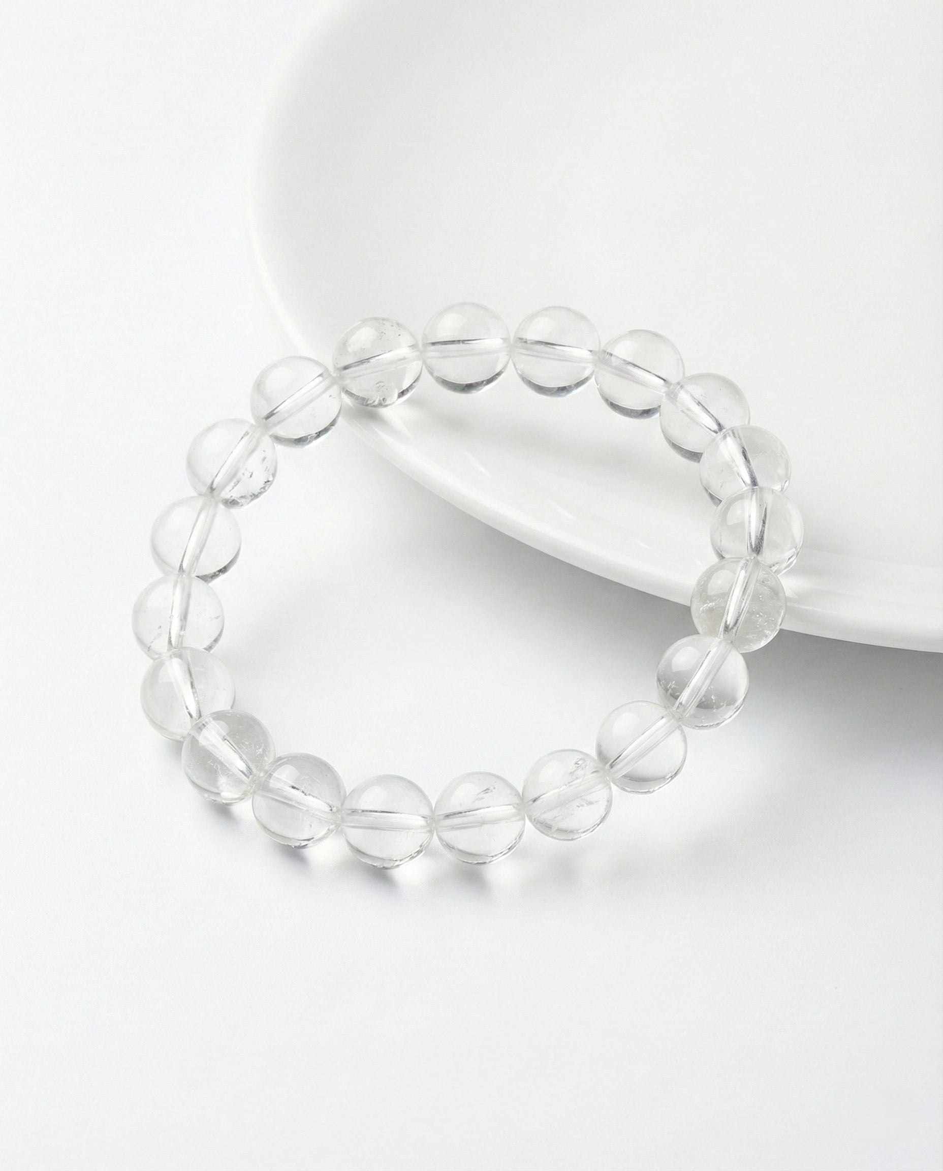 Natural Clear Quartz beaded bracelet with transparent round gemstones on black background.
