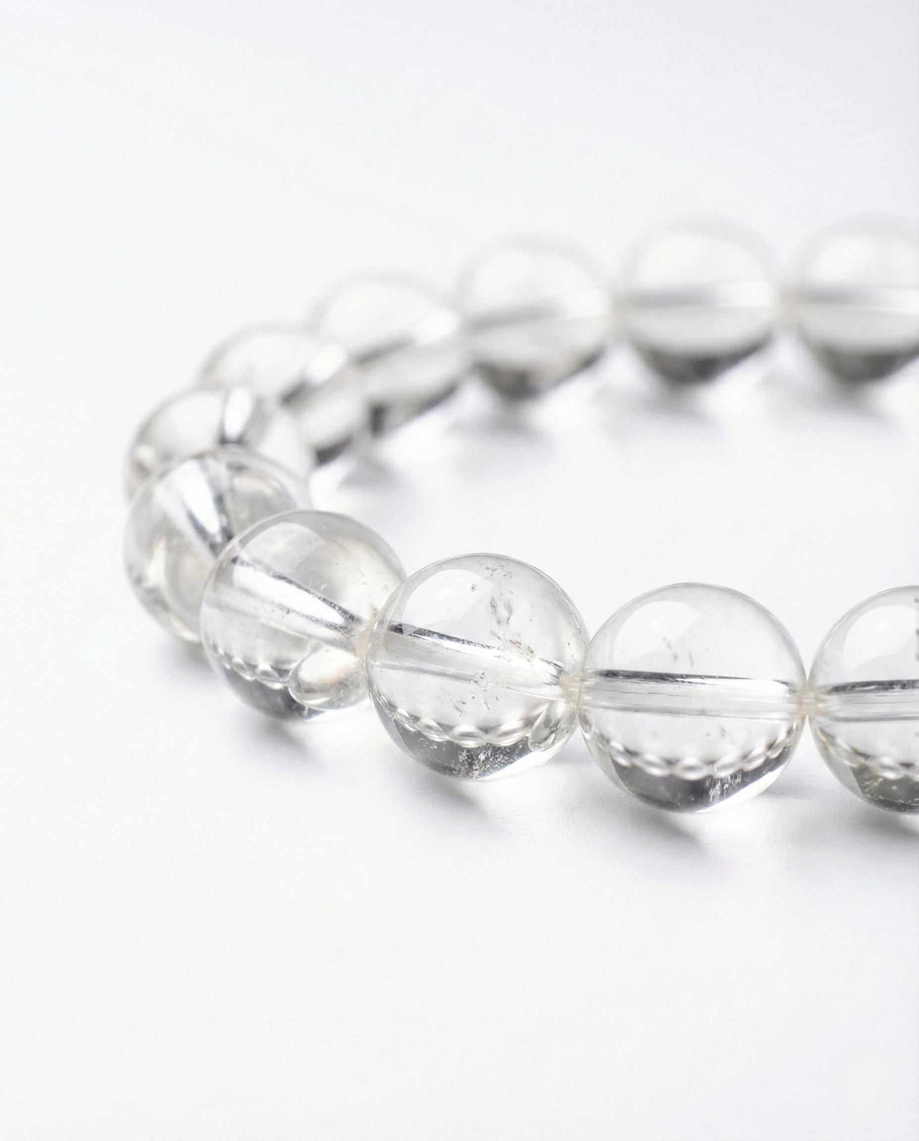 Natural Clear Quartz beaded bracelet with transparent round gemstones on black background.