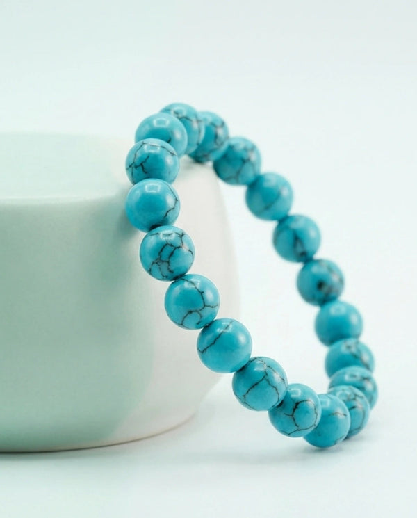 Natural Turquoise beaded bracelet featuring 8mm blue stones with black veining on white background.