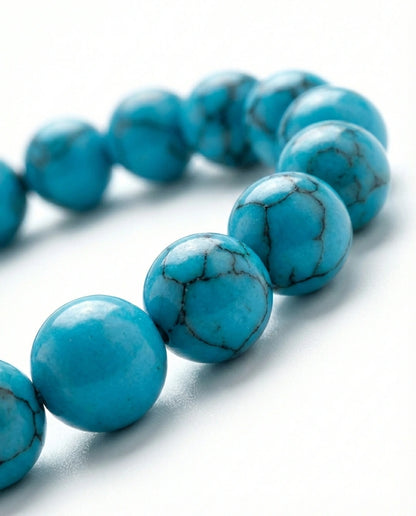 Natural Turquoise beaded bracelet featuring 8mm blue stones with black veining on white background.
